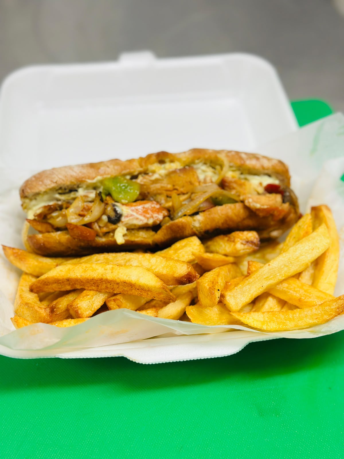 Chicken sub with peppers and onions, served with chips
